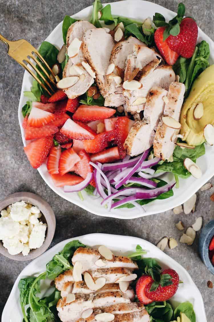 In just 30 minutes this Paleo + Whole30 savory and sweet strawberry chicken salad will be on the table! It's full of flavor and super easy to make! Simple chicken pairs perfectly with arugula, spinach, strawberries, avocado, red onion, sliced almonds and an easy balsamic dressing. Paleo + Whole30 | realsimplegood.com