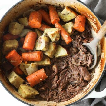 Shredded dutch oven pot roast in with carrots and potatoes