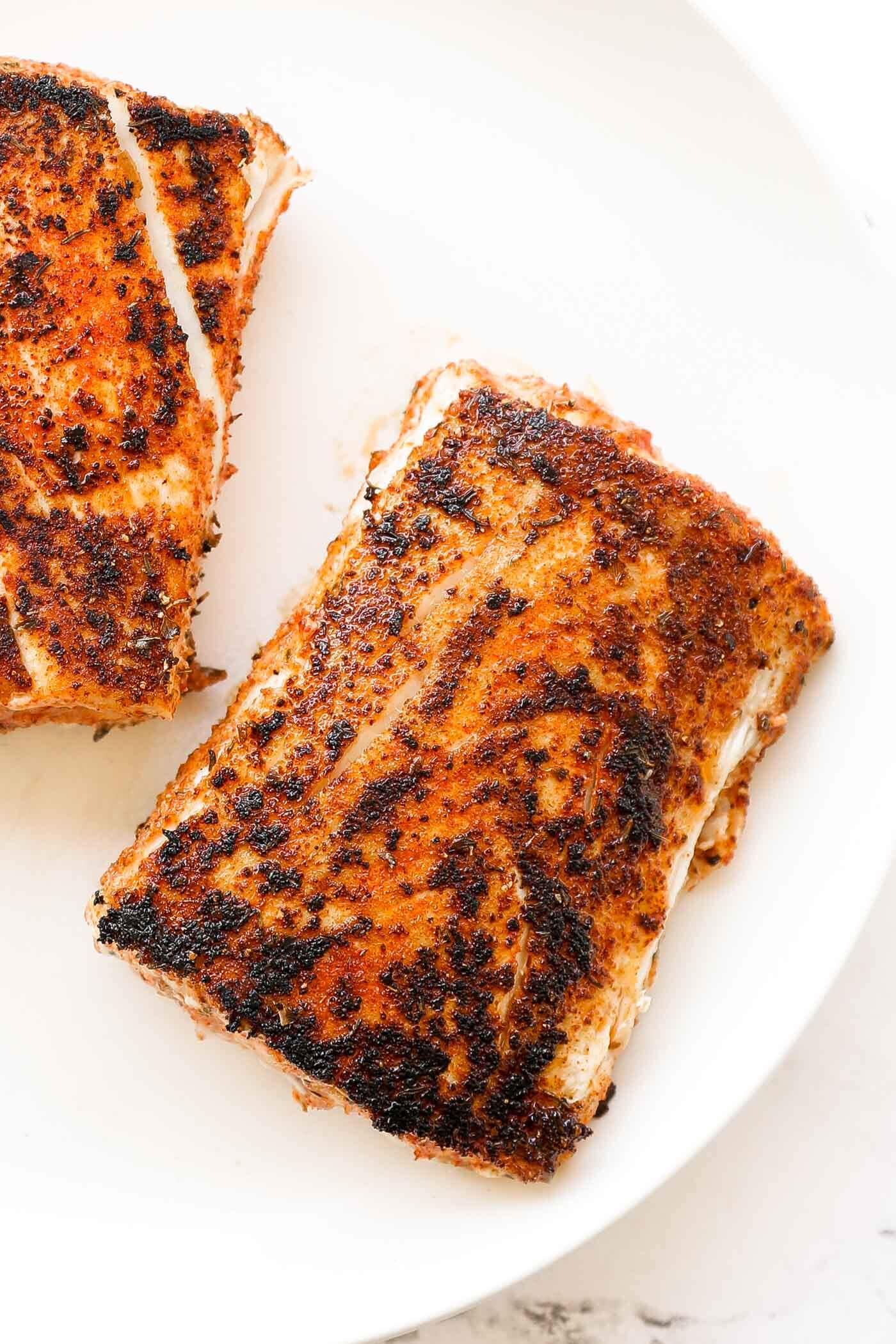 Mahi mahi with a blackened crust on a plate.