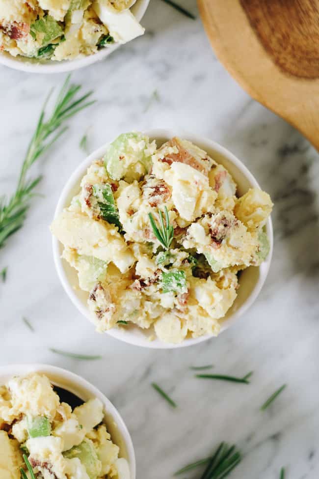 The best potato salad with bacon in a bowl with rosemary