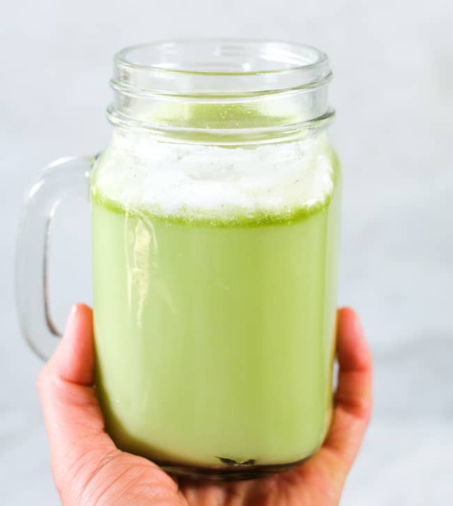 Iced matcha latte in a mason jar mug.