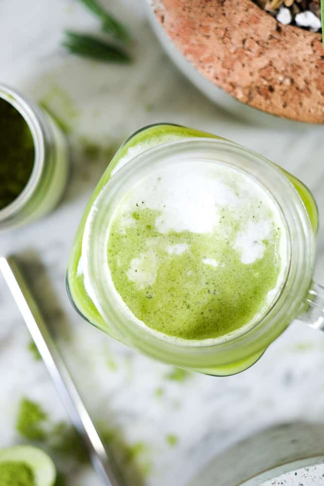 Iced matcha latte in a mason jar mug with straw. 