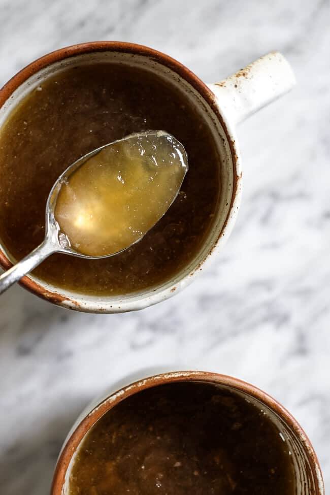 Two mugs of bone broth. Blog post about where to buy bone broth and why you should add it to your diet. 