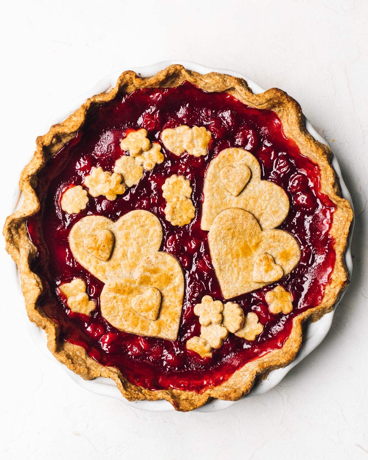 Overhead shot of cherry pie with fancy heart shaped toppings