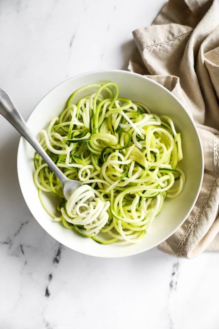 Overhead image of noodles in a bowl with a bite twirled around a fork.