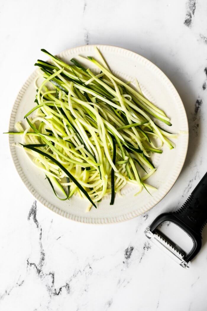 Image of zoodles on a plate, made from a veggie peeler.