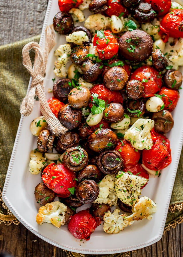 Overhead image of roasted cauliflower, tomatoes, and mushrooms with Italian seasoning