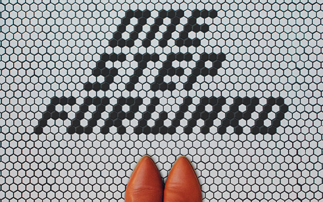 Standing on tiled floor that says one step forward. Inspiration for how to overcome fear of failure. 