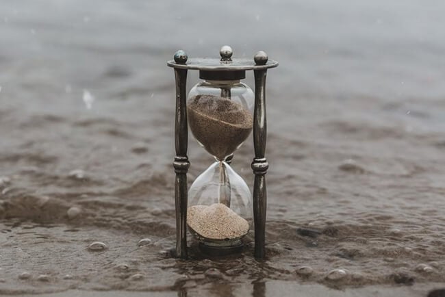 Hourglass on sand with water