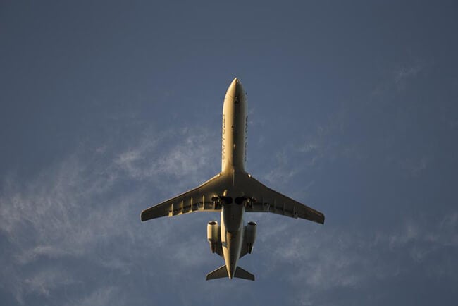 Image of plane flying with blue sky